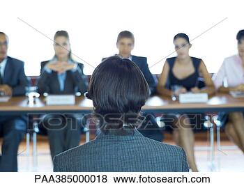 Stock Photo - executives sitting 
at conference 
table, looking 
at man in foreground. 
fotosearch - search 
stock photos, 
pictures, images, 
and photo clipart
