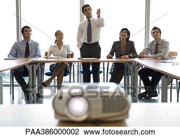 Stock Photo - businesspeople 
watching presentation, 
videoprojector 
in foreground. 
fotosearch - search 
stock photos, 
pictures, images, 
and photo clipart