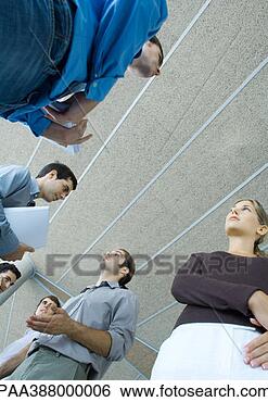 Stock Photo - group of young  business people  speaking, low  angle view. fotosearch  - search stock  photos, pictures,  images, and photo  clipart