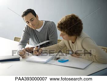 Picture - father helping 
teenage son with 
homework. fotosearch 
- search stock 
photos, pictures, 
images, and photo 
clipart