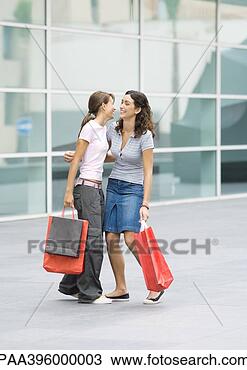 Stock Photo - teen girls holding 
shopping bags 
giving each other 
hug. fotosearch 
- search stock 
photos, pictures, 
images, and photo 
clipart