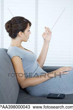 Stock Photo - woman sitting 
on sofa, looking 
at fingernails, 
wireless phone 
by side. fotosearch 
- search stock 
photos, pictures, 
images, and photo 
clipart