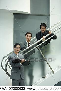 Stock Photo - three business 
executives standing 
along staircase, 
looking at camera. 
fotosearch - search 
stock photos, 
pictures, images, 
and photo clipart