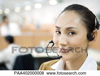 Stock Photo - woman wearing 
headset, smiling 
at camera. fotosearch 
- search stock 
photos, pictures, 
images, and photo 
clipart