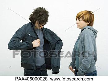 Stock Photo - young man and 
woman standing, 
 man putting on 
jacket while woman. 
fotosearch - search 
stock photos, 
pictures, images, 
and photo clipart