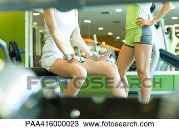 Banco de Imagem - dois,  mulheres, 
 ficar,  peso, 
 sala,  parcial, 
 vista. fotosearch 
- busca de fotos, 
imagens e clipart