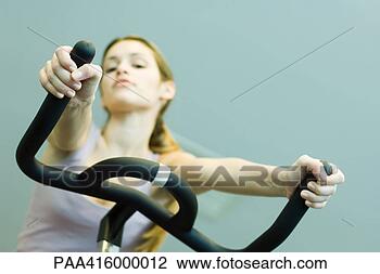 Stock Photo - woman riding exercise 
bike. fotosearch 
- search stock 
photos, pictures, 
images, and photo 
clipart