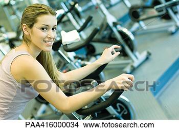 Stock Photo - woman riding exercise 
bike. fotosearch 
- search stock 
photos, pictures, 
images, and photo 
clipart