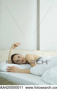 Arquivo de Fotografia - jovem,  mulher, 
 mentindo,  cama, 
 sorrindo. fotosearch 
- busca de fotos, 
imagens e clipart