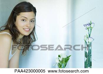 Banco de Imagem - jovem,  mulher, 
 vasos,  flores, 
 sorrindo,  câmera. 
fotosearch - busca 
de fotos, imagens 
e clipart