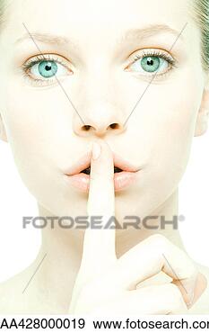 Stock Photograph - teenage girl holding 
finger over lips, 
close-up, front 
view. fotosearch 
- search stock 
photos, pictures, 
images, and photo 
clipart
