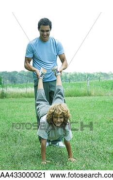 Stock Photography - man holding boy's 
feet while boy 
balances on hands. 
fotosearch - search 
stock photos, 
pictures, images, 
and photo clipart