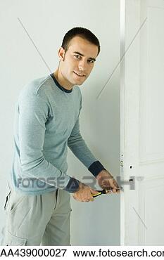 Picture - man unscrewing 
lock on door. 
fotosearch - search 
stock photos, 
pictures, images, 
and photo clipart