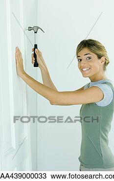 Stock Photo - woman hammering 
nail into wall. 
fotosearch - search 
stock photos, 
pictures, images, 
and photo clipart