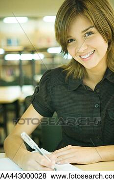 Stock Photo - female college 
student sitting 
at table in library, 
studying. fotosearch 
- search stock 
photos, pictures, 
images, and photo 
clipart
