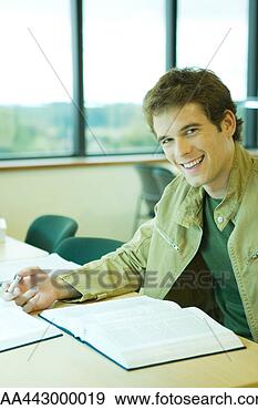 Stock Photograph - male college student 
sitting in library, 
smiling at camera. 
fotosearch - search 
stock photos, 
pictures, images, 
and photo clipart