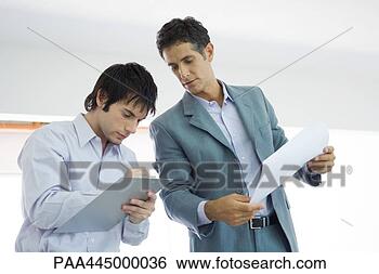 Stock Photo - young man writing 
on clipboard, 
mature man looking 
over shoulder. 
fotosearch - search 
stock photos, 
pictures, images, 
and photo clipart