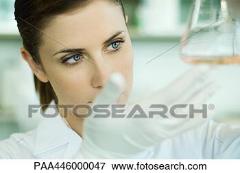 Picture - young female researcher 
holding up flask, 
close-up. fotosearch 
- search stock 
photos, pictures, 
images, and photo 
clipart