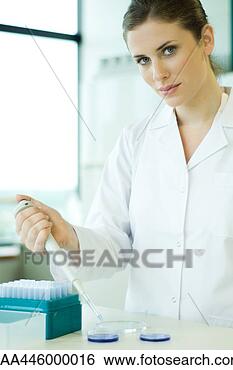 Stock Photo - young woman working 
in scientific 
laboratory,  holding 
dropper over. 
fotosearch - search 
stock photos, 
pictures, images, 
and photo clipart
