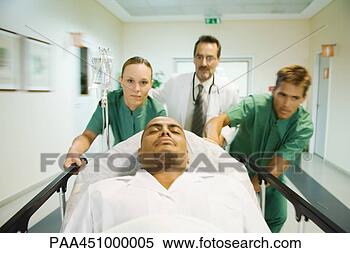 Stock Image - emergency room 
staff pushing 
man on stretcher. 
fotosearch - search 
stock photos, 
pictures, images, 
and photo clipart