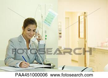 Stock Photo - young woman in 
doctor's office, 
using phone, writing. 
fotosearch - search 
stock photos, 
pictures, images, 
and photo clipart