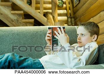 Banco de Imagem - menino,  reclinar, 
 sofá,  leitura, 
 livro. fotosearch 
- busca de fotos, 
imagens e clipart
