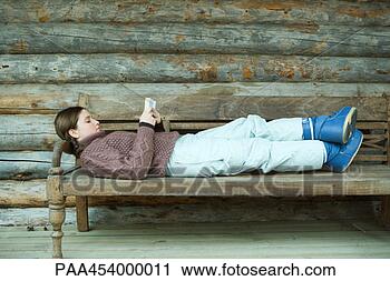Stock Photography - teenage girl lying 
on back, reading 
book, wearing 
winter clothing. 
fotosearch - search 
stock photos, 
pictures, images, 
and photo clipart