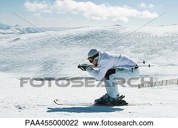 Stock Photo - young female skier 
crouching, side 
view, full length 
portrait. fotosearch 
- search stock 
photos, pictures, 
images, and photo 
clipart