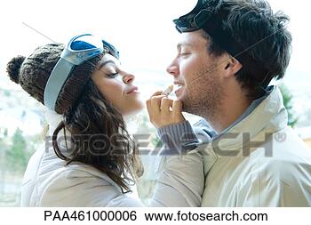 Stock Photo - young woman applying 
lipbalm to boyfriend's 
lips,  both dressed 
in. fotosearch 
- search stock 
photos, pictures, 
images, and photo 
clipart