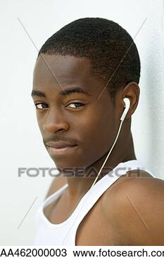 Stock Photo - male listening 
to earphones, 
looking at camera, 
portrait. fotosearch 
- search stock 
photos, pictures, 
images, and photo 
clipart