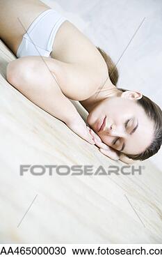 Stock Photography - woman reclining 
in floor, head 
resting on arms, 
eyes closed. fotosearch 
- search stock 
photos, pictures, 
images, and photo 
clipart