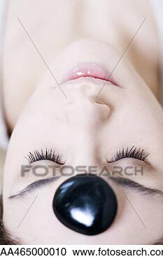 Stock Photography - young woman reclining 
with pebble on 
forehead, eyes 
closed, close-up. 
fotosearch - search 
stock photos, 
pictures, images, 
and photo clipart