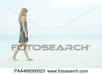 Stock Photo - young woman walking 
on beach, using 
cell phone, full 
length. fotosearch 
- search stock 
photos, pictures, 
images, and photo 
clipart