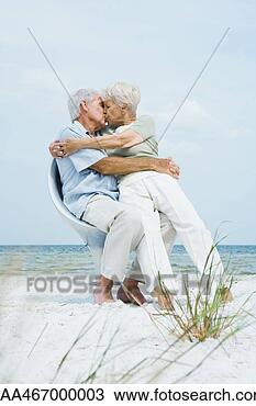 Stock Photo - senior couple 
sitting in chair 
together on beach, 
 hugging and. 
fotosearch - search 
stock photos, 
pictures, images, 
and photo clipart