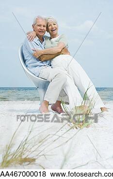 Stock Photo - senior couple 
sitting in chair 
together on beach, 
 embracing,  woman. 
fotosearch - search 
stock photos, 
pictures, images, 
and photo clipart