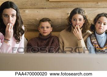 Arquivo de Fotografias - meninas,  jovem, 
 menino,  menina, 
 observar,  tv, 
 junto,  snacking. 
fotosearch - busca 
de fotos, imagens 
e clipart
