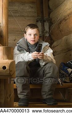 Banco de Imagem - menino,  vestido, 
 esqui,  roupas, 
 segurando,  célula, 
 telefone. fotosearch 
- busca de fotos, 
imagens e clipart
