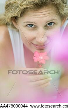 Stock Photo - woman smelling 
flower, looking 
at camera. fotosearch 
- search stock 
photos, pictures, 
images, and photo 
clipart