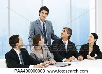 Stock Photo - business leader 
standing behind 
group of colleagues 
at meeting table. 
fotosearch - search 
stock photos, 
pictures, images, 
and photo clipart
