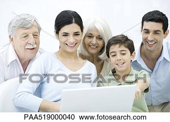 Stock Photography - multi-generation 
family gathered 
around laptop 
computer, smiling. 
fotosearch - search 
stock photos, 
pictures, images, 
and photo clipart