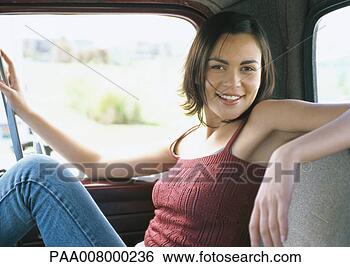 Stock Photo - young woman sitting 
inside vehicle, 
smiling at camera. 
fotosearch - search 
stock photos, 
pictures, images, 
and photo clipart