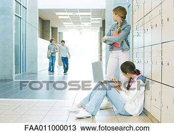 Stock Photo - two high school 
girls by lockers, 
watching teen 
boys approaching. 
fotosearch - search 
stock photos, 
pictures, images, 
and photo clipart