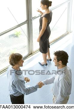 Stock Photo - executives shaking 
hands during cocktail 
party. fotosearch 
- search stock 
photos, pictures, 
images, and photo 
clipart