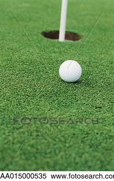 Stock Image - golf ball on turf 
near hole, close-up. 
fotosearch - search 
stock photos, 
pictures, images, 
and photo clipart