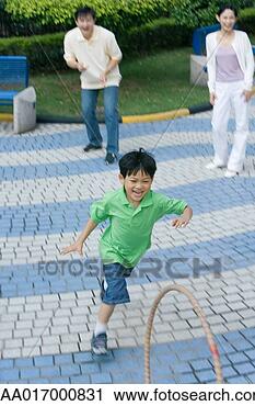 Stock Photography - boy chasing hoop, 
parents watching. 
fotosearch - search 
stock photos, 
pictures, images, 
and photo clipart