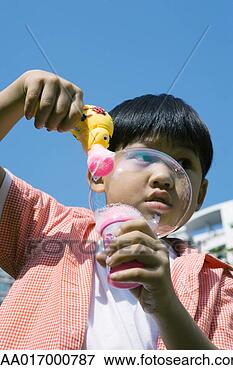 Picture - boy making bubbles 
with bubble gun. 
fotosearch - search 
stock photos, 
pictures, images, 
and photo clipart