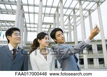 Stock Photo - businessman taking 
photo of self 
and two colleagues 
with cell phone. 
fotosearch - search 
stock photos, 
pictures, images, 
and photo clipart