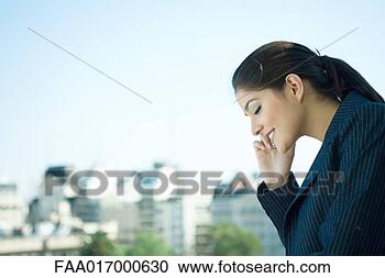 Stock Photography - businesswoman 
using cell phone, 
city skyline in 
background. fotosearch 
- search stock 
photos, pictures, 
images, and photo 
clipart