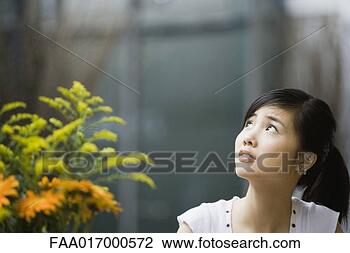 Stock Photo - young woman looking 
up and raising 
eyebrows. fotosearch 
- search stock 
photos, pictures, 
images, and photo 
clipart