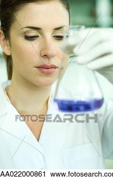 Stock Photography - female lab worker 
holding up flask, 
inspecting its 
contents. fotosearch 
- search stock 
photos, pictures, 
images, and photo 
clipart